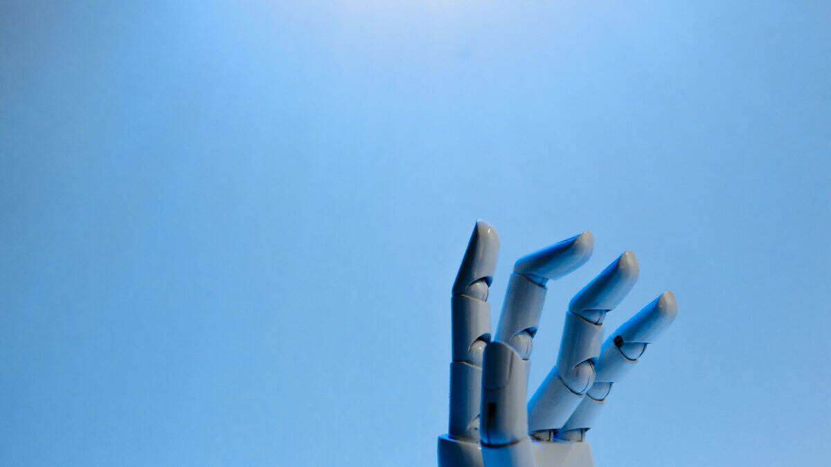 A robotic hand with articulated fingers reaching upward against a blue background