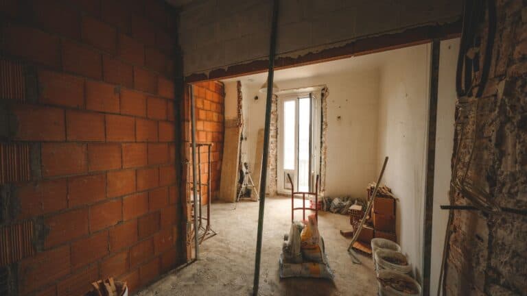 A partially renovated room with exposed brick walls and construction materials